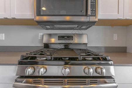 厨房内墙架起的微波炉和一个射程的烹饪台紧闭图片