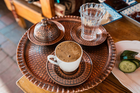 土耳其传统咖啡铜盘上有杯子和一杯水图片