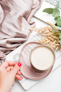 美丽的粉红色咖啡杯白桌上有毯子鲜花图片