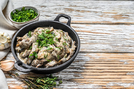 BeefStroganoff配有蘑菇和新鲜面纱白色背景顶级视图片