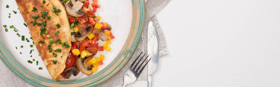 白桌上用叉子刀和叉子包着蔬菜的图片