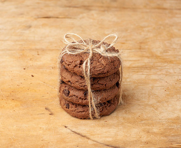 圆巧克力曲奇饼干堆叠在木形背景图片