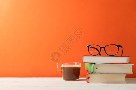 书本眼镜和咖啡杯橙色背图片