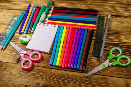 笔和笔记本木制书桌上的一套学校文具用品返背景