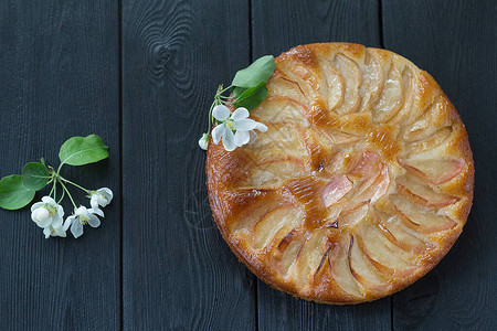 黑桌上有苹果树花的新鲜烤苹果馅饼在家做图片