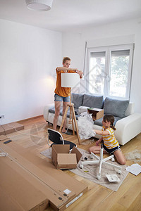 母亲和女儿在新公寓内装配家具搬图片