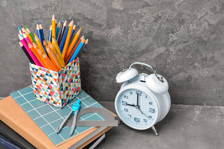 一套学校用品和桌子上的时钟图片