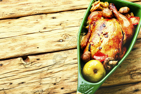 旧木桌上的苹果烤鸡苹果炸鸡美味的芳香烤鸡背景图片