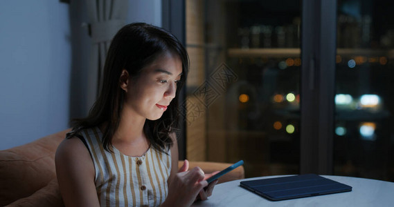 女人晚上在家使用手机图片