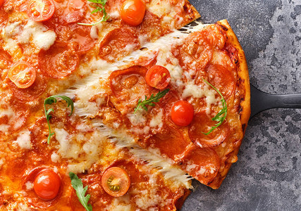 薄荷披萨和樱桃西红柿的切片在灰石背景上切成美图片