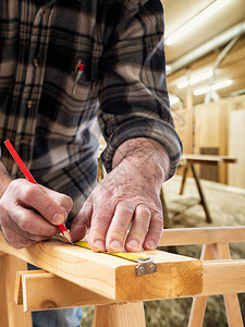 特写木匠用铅笔和仪表在木板上标记测量值建筑图片