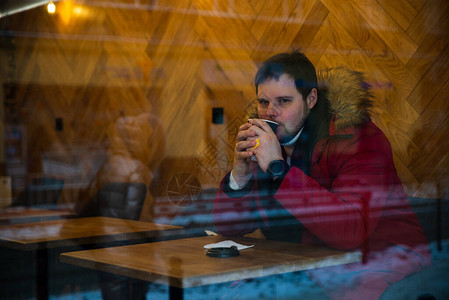 在咖啡馆的男人红色冬季大衣喝图片