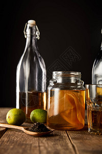 靠近石灰香料和瓶子的红茶菌放在木桌上图片