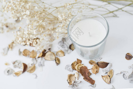 白色桌子上带有花卉装饰的蜡烛舒适和hygge背景图片