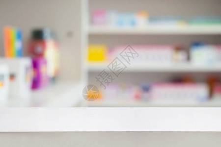 药房背景中带有模糊货架的空白色药房柜台图片