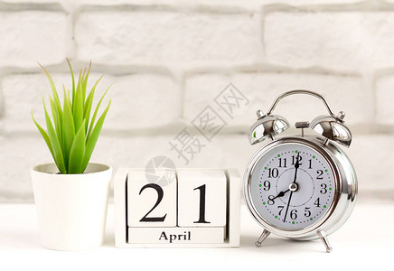 月21日在白色背景的木制日历上闹钟和日历图片