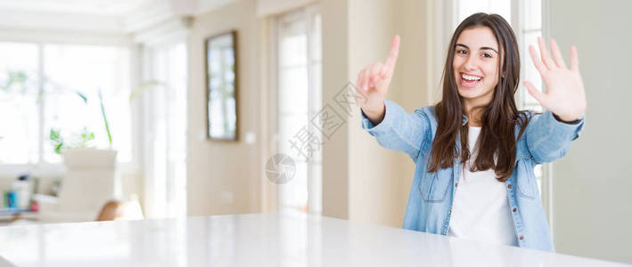 美丽的年轻女子坐在家里的白色桌子上的广角照片图片