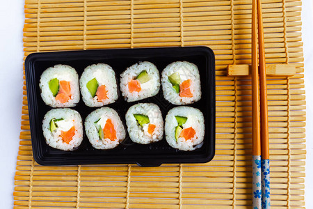 一套寿司卷和筷子在寿司垫底图片