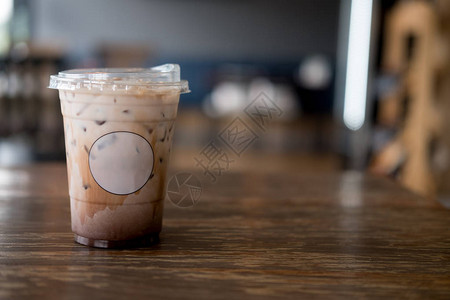 鲜冰的摩卡咖啡用塑料杯装在木制桌上早图片