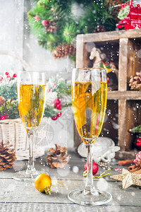 两杯香槟圣诞装饰品放在木雪上快乐和圣诞节庆典图片