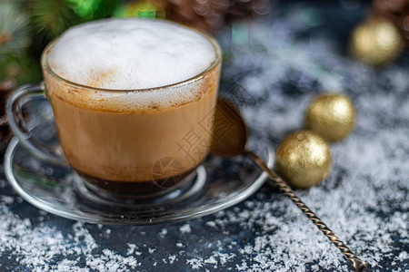 卡布奇诺在一个透明的杯子里有白色的奶霜新年装饰品圣诞树枝喜悦情图片