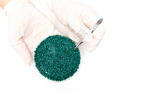 塑料颗粒颗粒中聚合物的着色剂戴手套的工人用镊子背景图片