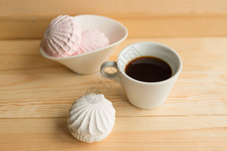 白色的Zefir和咖啡杯在木制桌子图片