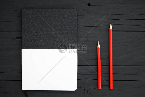 空白笔记本和铅笔黑木桌上的红铅笔和空图片