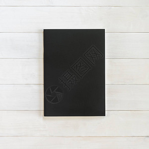 书籍模型空白黑色皮革A4尺寸封面模板平铺在白色木桌上图片
