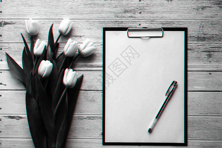 白色的郁金香花束在木蓝色背景与空白纸片剂具有3D故障效图片