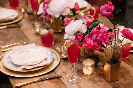 餐厅内配有眼镜菜肴和鲜花装饰的优雅婚礼桌华丽质朴的长婚礼桌婚礼装饰概念粉色白色背景图片