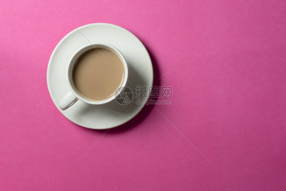 粉红纸背景的陶瓷杯图片
