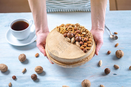 配有核桃杏仁麦当米和蓝木背景的栗子花椰子的原始坚果蛋糕健康背景图片