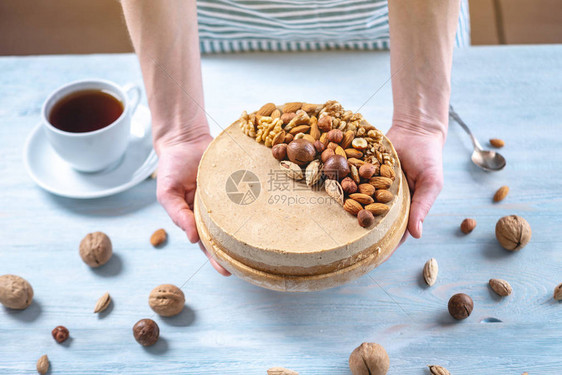 配有核桃杏仁麦当米和蓝木背景的栗子花椰子的原始坚果蛋糕健康图片