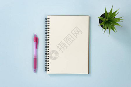 无线类型和办公室植物与红笔的螺旋笔记本或春笔记本图片