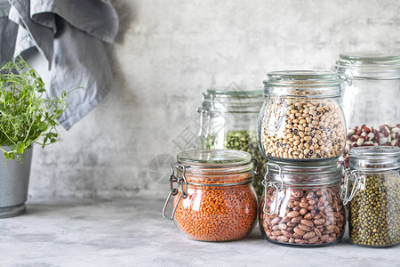 木制桌上玻璃罐子中不同豆类的一组素食者的蛋白质来源健康饮食概图片
