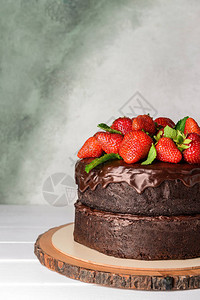 美味巧克力蛋糕桌上草莓和浅背景的鲜奶图片