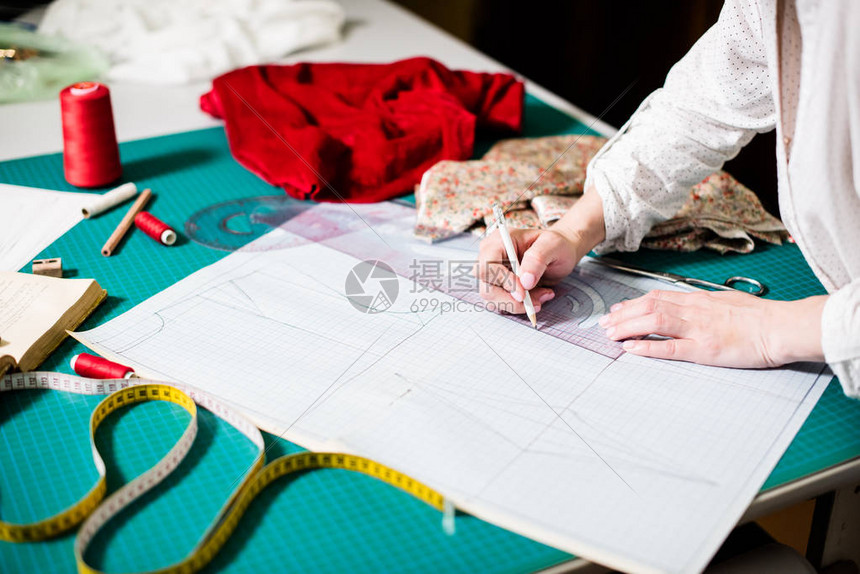在工作室工作的女裁缝手工具和织物样品在裁缝车间内部特图片