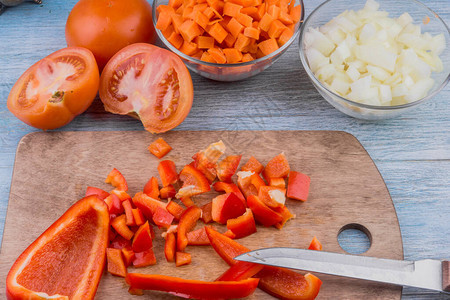 木板上切丁的红辣椒和素汤蔬菜图片