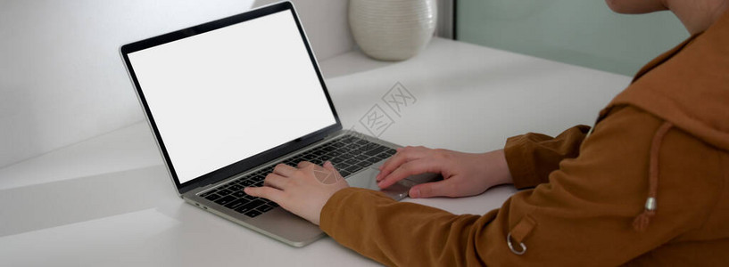 女自由职业者在坐简单工作场所时用模拟笔记本电脑打图片