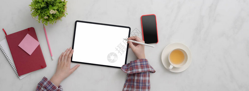 在大理石台空白屏幕板智能手机用品和茶杯上工作的女自由职背景图片