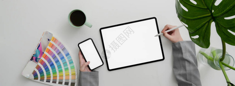 从事模拟智能手机和大理石桌上配有用品咖啡杯和装饰的平板电脑的设图片