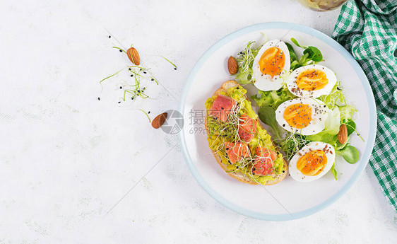 早餐健康的开放式三明治配鳄梨和鲑鱼煮鸡蛋香草白盘子上的奇亚籽和复制空间健康的蛋白质食物图片