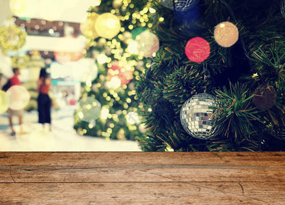 在圣诞节或新年快乐时间背景前的空旧木桌圣诞树与五颜六色的球假日背景产图片