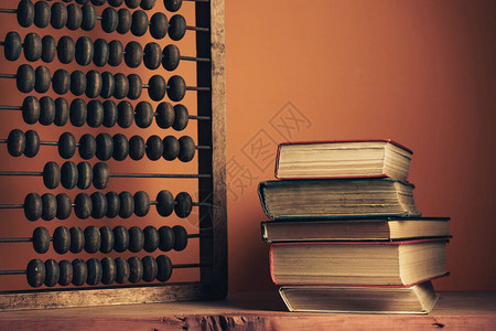 漂亮的旧书和红木桌上的老式木制算盘背景图片