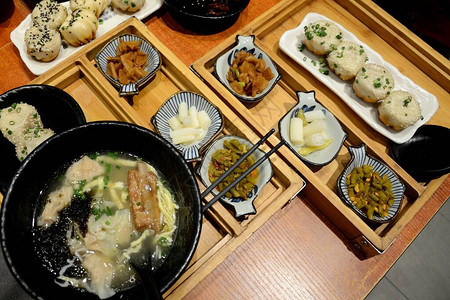 广州餐桌上的典型中餐一碗面条和排骨汤辣味小吃豆大蒜和背景图片