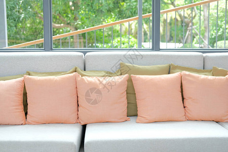 客厅沙发椅上的橙色枕头在图片