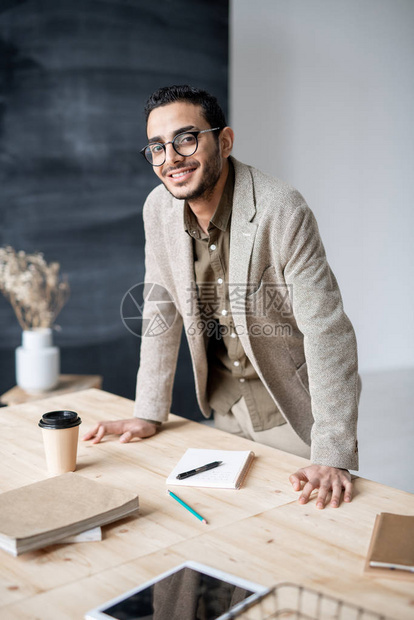 年轻笑着的企业家或正式服装经理在工作期间弯曲木板时看着你图片