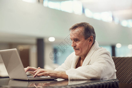 成功老年男子使用笔记本电脑的肖像图片