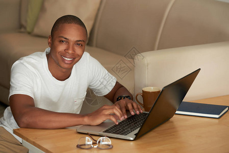 在家做笔记本电脑工作的年轻黑人快图片